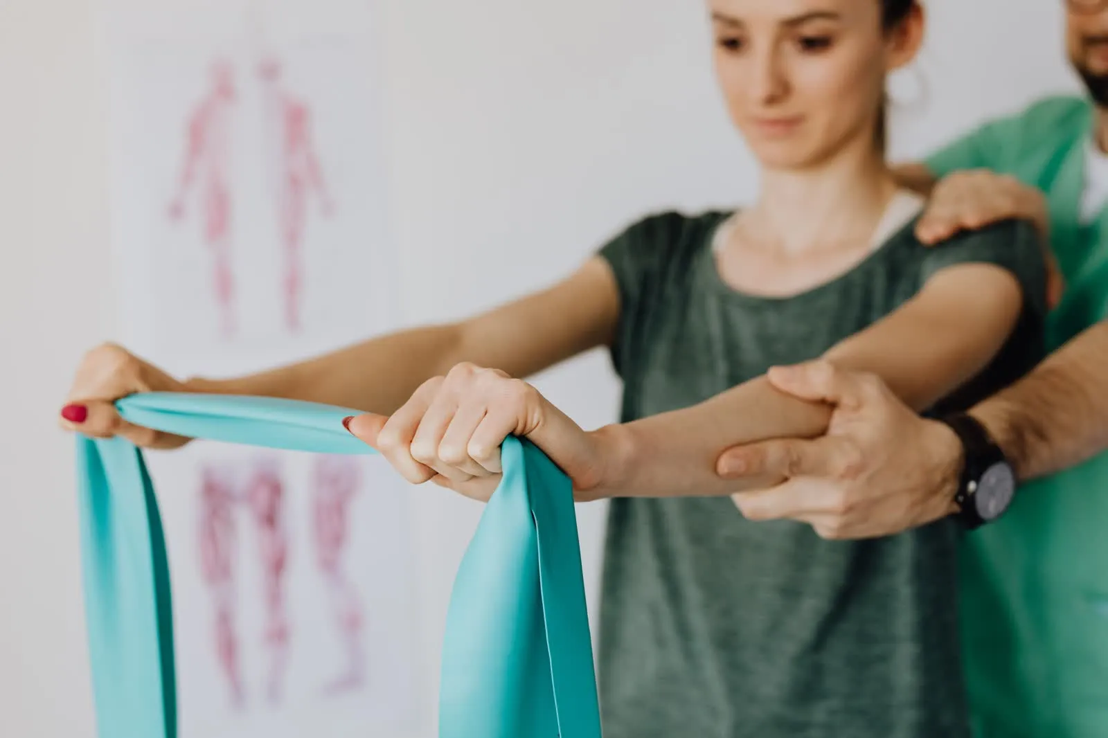 A physiotherapist working with a patient using a stretch band in a clinic.