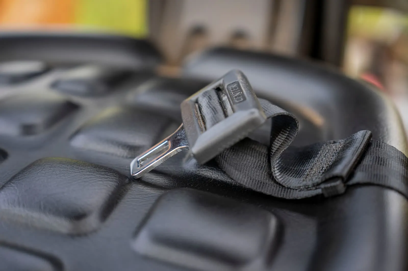 Close-up of a seatbelt buckle on a car seat.