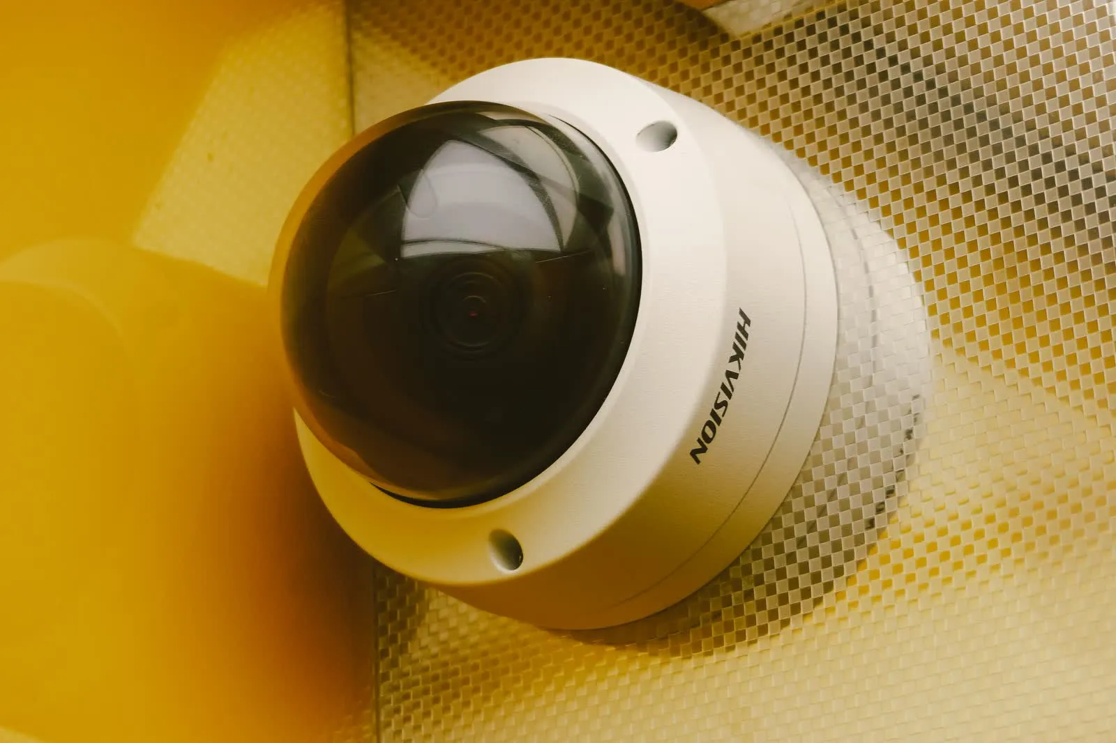 A security camera mounted on an interior wall, viewed from below.